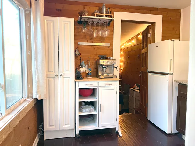 a view of kitchen with furniture and refrigerator