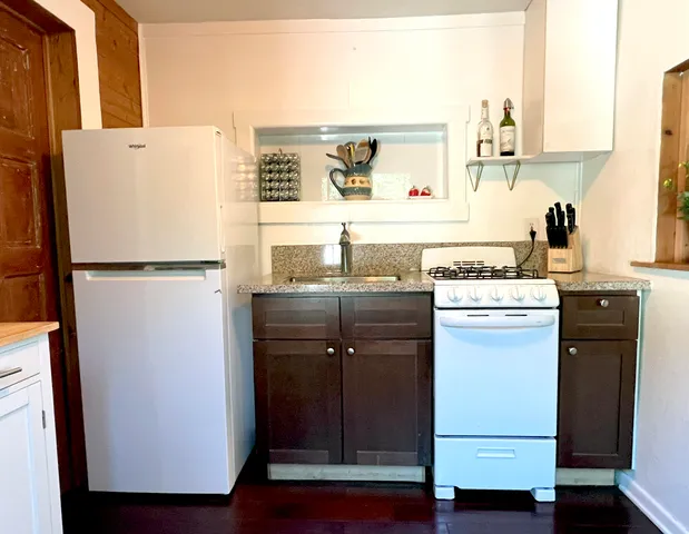 a kitchen with a refrigerator sink stove and cabinets