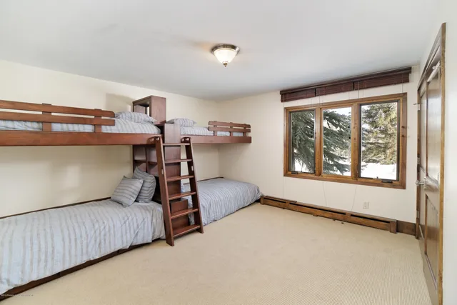 a bedroom with a bed and windows