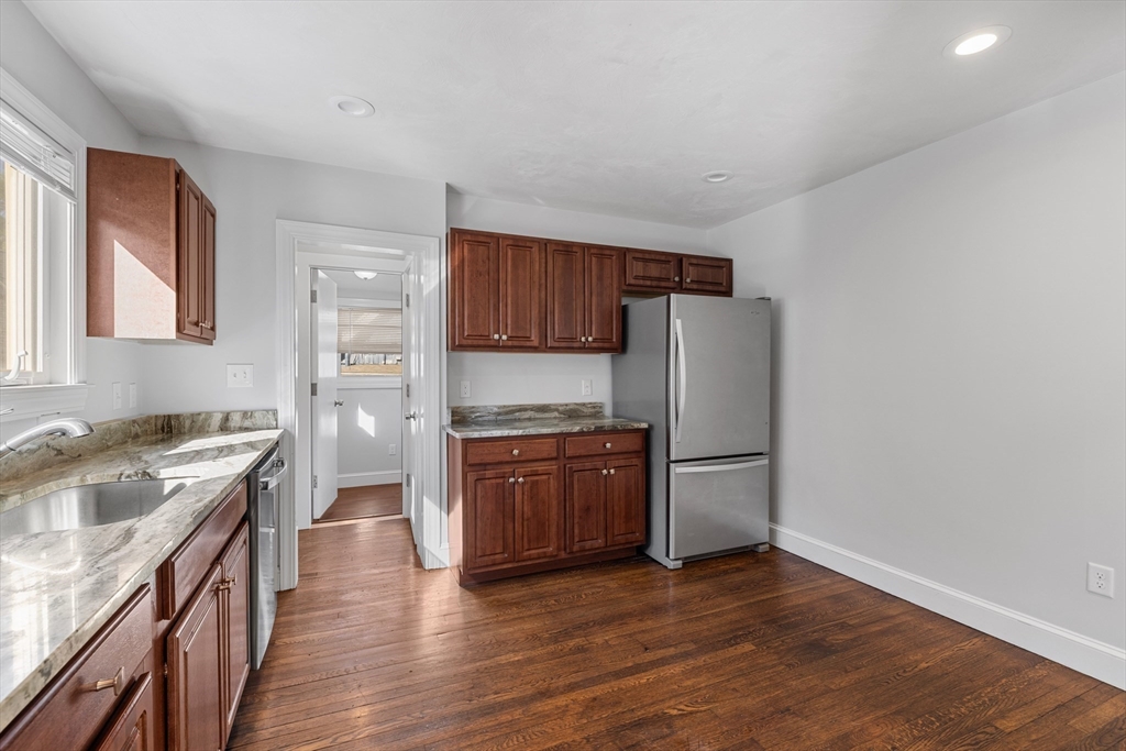 48 High Street, Unit 48 Somerville, MA 02144 - Photo 4 of 23 a kitchen with granite countertop wooden floors and stainless steel appliances