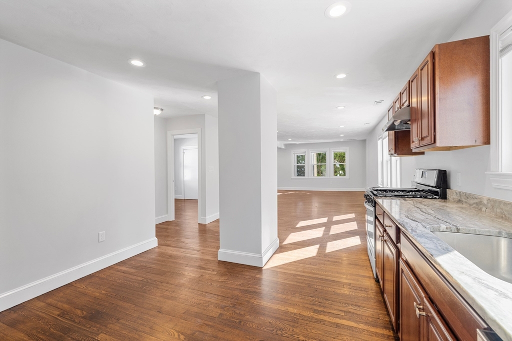 48 High Street, Unit 48 Somerville, MA 02144 - Photo 5 of 23 a view of a kitchen center island wooden floor and stainless steel appliances