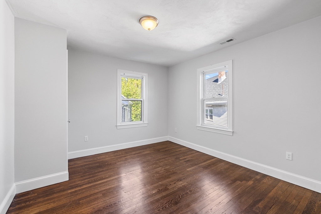 48 High Street, Unit 48 Somerville, MA 02144 - Photo 10 of 23 an empty room with window and wooden floor
