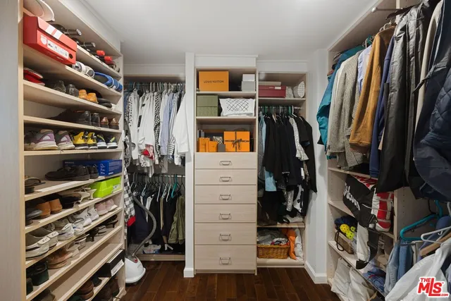 a view of walk in closet with clothes and shoes