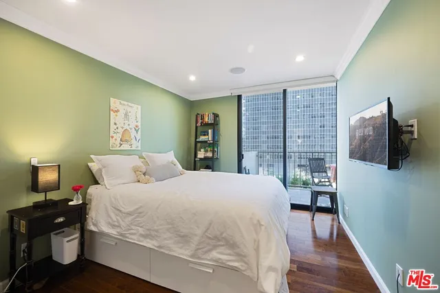 a spacious bedroom with a bed and wooden floor