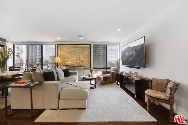 a living room with furniture flat screen tv and a large window