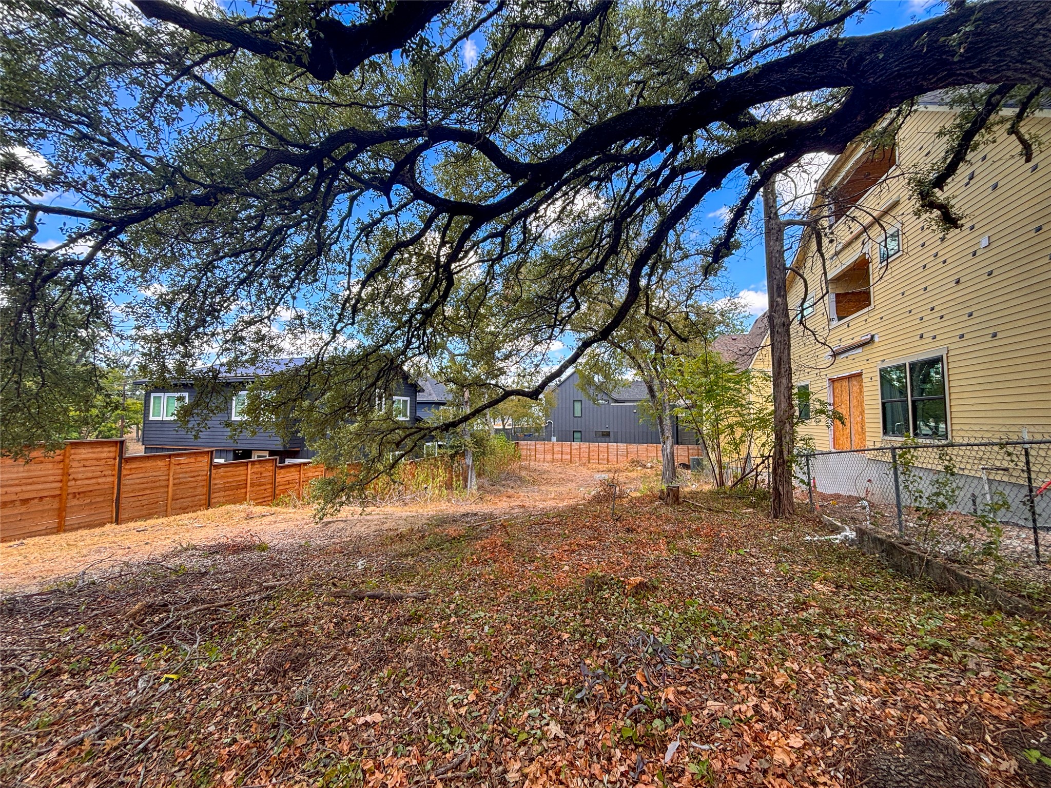 4602 Santa Anna Street Austin, TX 78721 - Photo 3 of 14 Mature trees shade a spacious backyard framed by wood fencing.