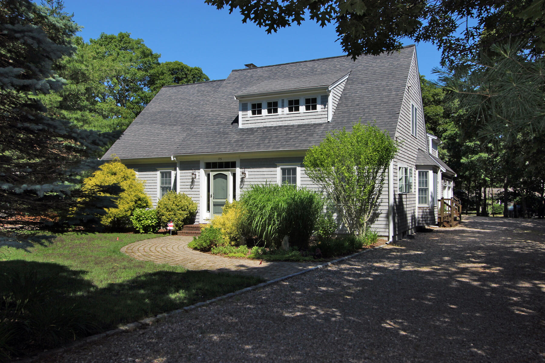 195 Cathedral Road Brewster, MA 02631 - Photo 1 of 54 a front view of a house with a garden