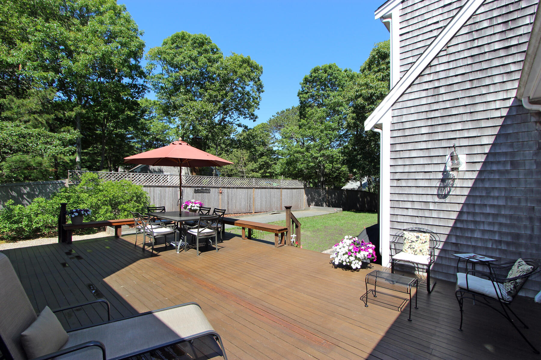 195 Cathedral Road Brewster, MA 02631 - Photo 9 of 54 a view of a patio with table and chairs under an umbrella
