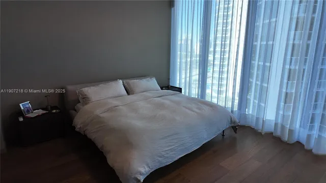 a bed sitting in a bedroom next to a window