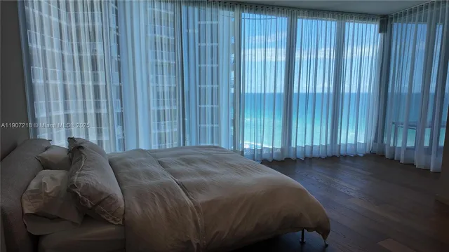 a bed sitting in a spacious bedroom next to a window