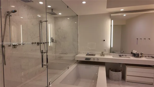 a bathroom with a double vanity sink a mirror and a shower