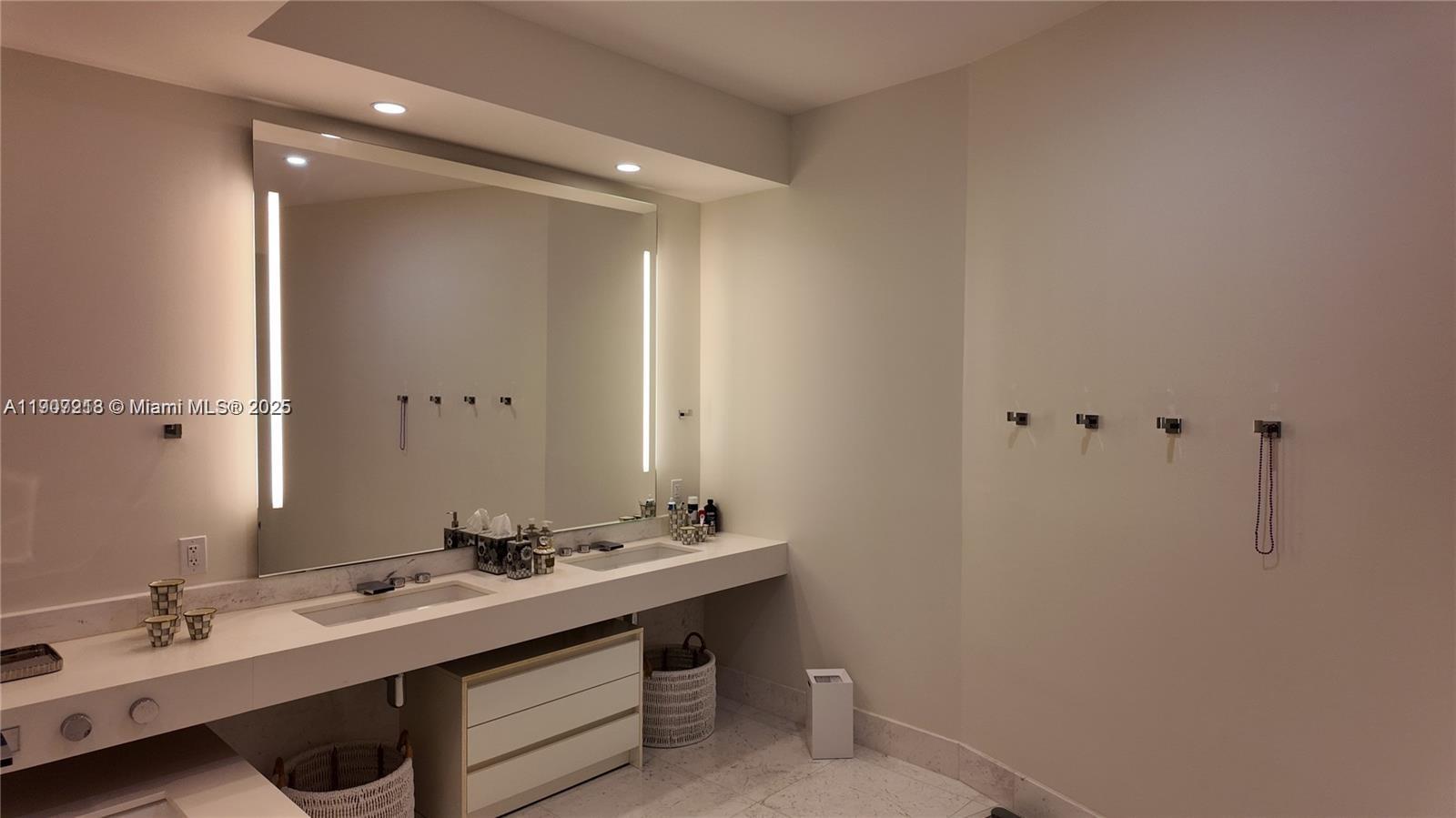18555 Collins Avenue, Unit 905 Sunny Isles Beach, FL 33160 - Photo 28 of 38 a bathroom with a sink a vanity and a mirror