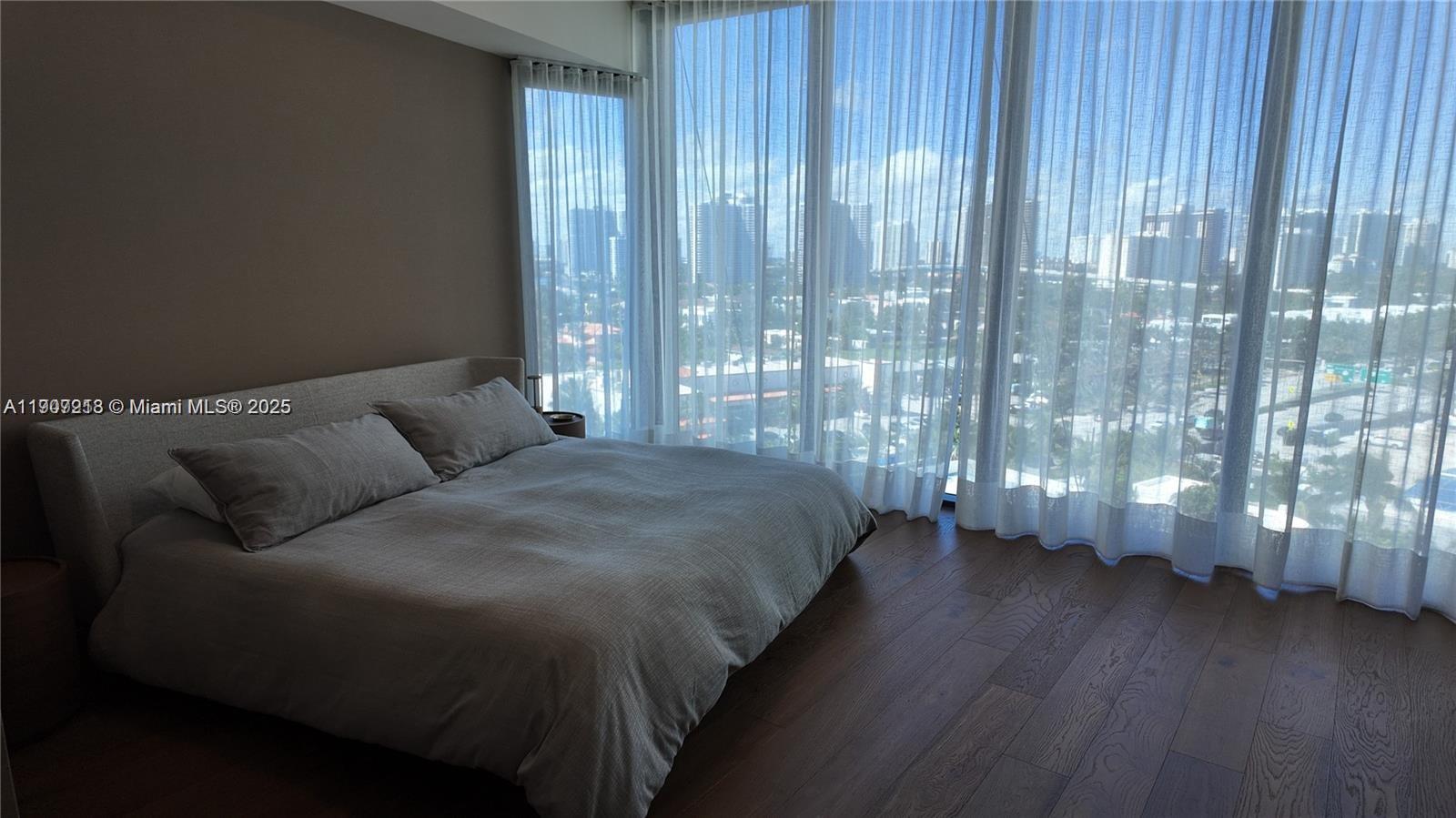 18555 Collins Avenue, Unit 905 Sunny Isles Beach, FL 33160 - Photo 31 of 38 a bed sitting in a bedroom next to a window