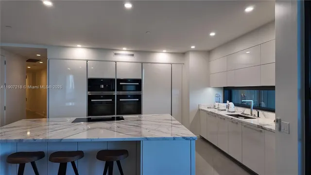 a kitchen with stainless steel appliances kitchen island granite countertop a sink and cabinets