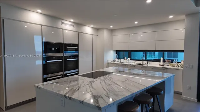 a kitchen with kitchen island a stove and a refrigerator with wooden floor