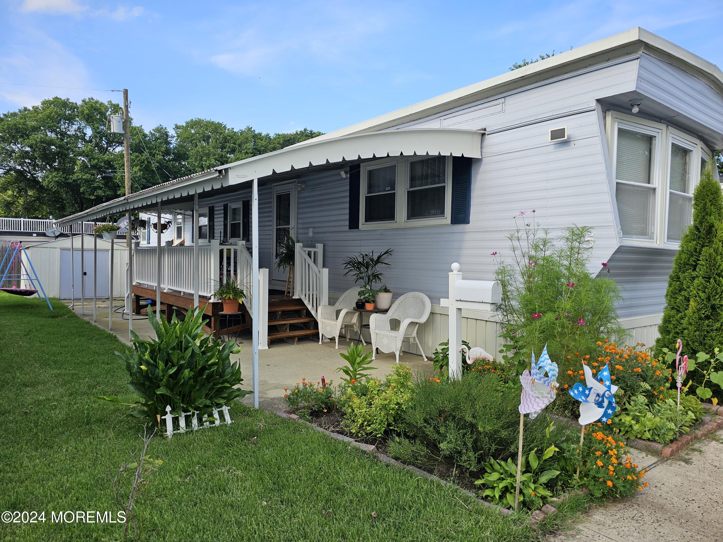 a view of a house with backyard and sitting area