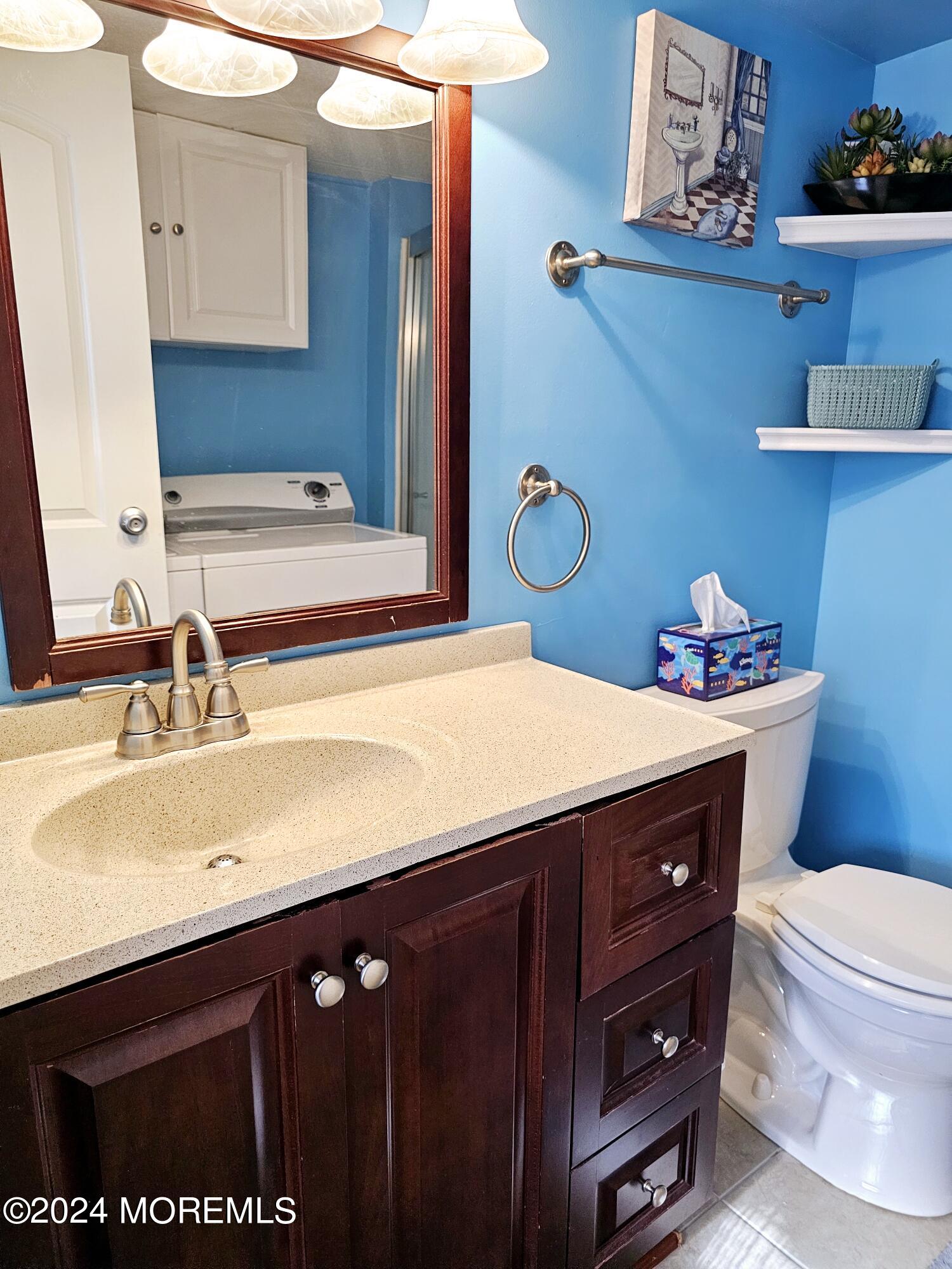 5 Kane Lane Middletown, NJ 07748 - Photo 15 of 23 a bathroom with a sink a toilet and a mirror