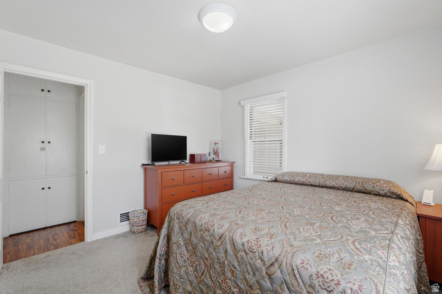 7576 South Jefferson Street Midvale, UT 84047 - Photo 19 of 53 Bedroom featuring light gray walls, plush gray carpeting, a window with horizontal blinds, and a built-in white cabinet with multiple doors
