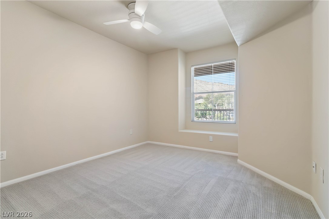 10550 West Alexander Road, Unit 2060 Las Vegas, NV 89129 - Photo 25 of 45 Comfortable room features a ceiling fan and natural light through the window.