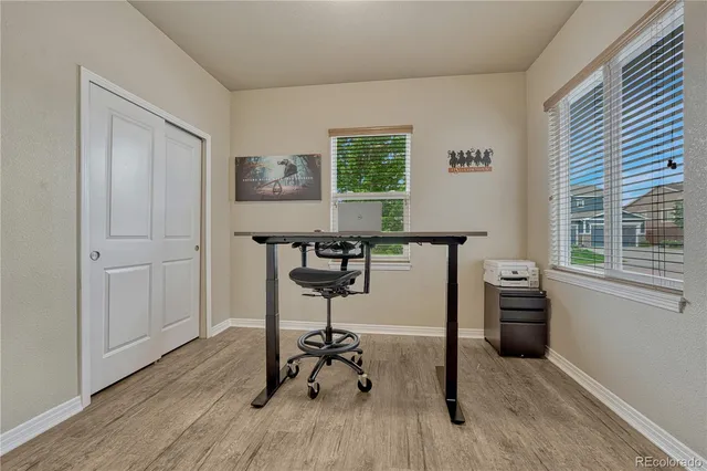 a view of a workspace with furniture and a window