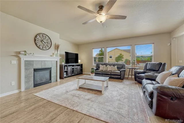 a living room with furniture a fireplace and a large window