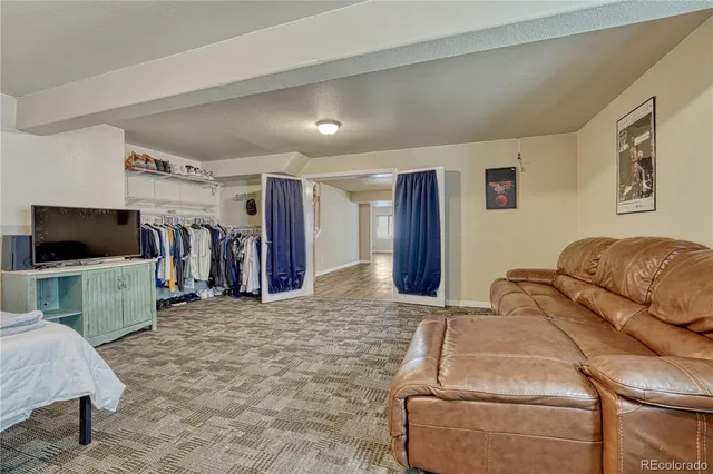 a living room with furniture a flat screen tv and a wooden floor