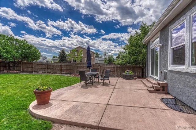 a view of a patio with a table chairs and a fire pit