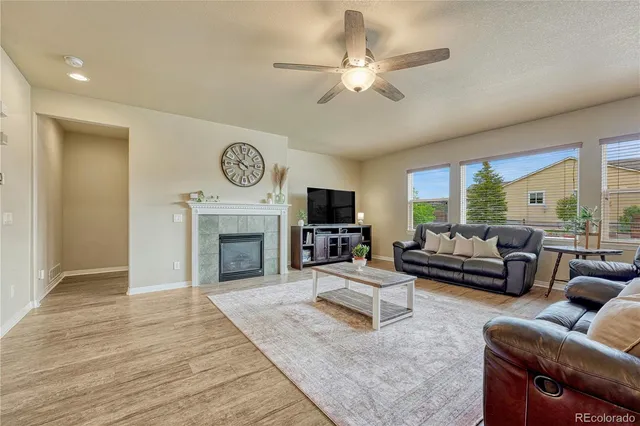 a living room with furniture a fireplace and a large window