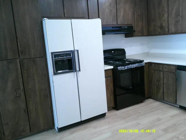 a kitchen with a refrigerator sink and cabinets