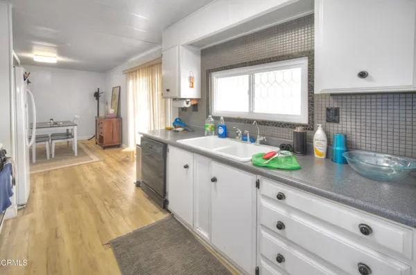 a kitchen that has a sink and a wooden floor