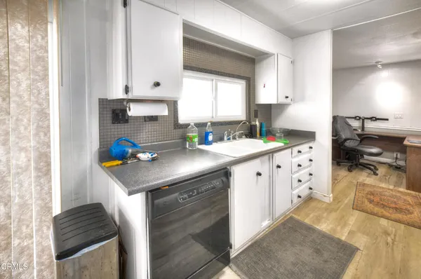 a kitchen with granite countertop a sink stove and cabinets