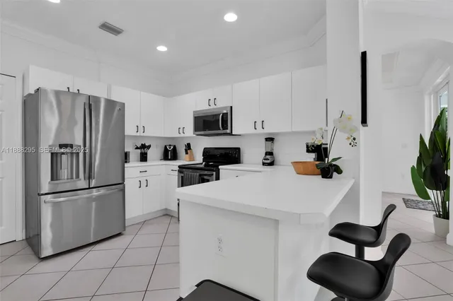 a kitchen with stainless steel appliances a refrigerator sink and microwave