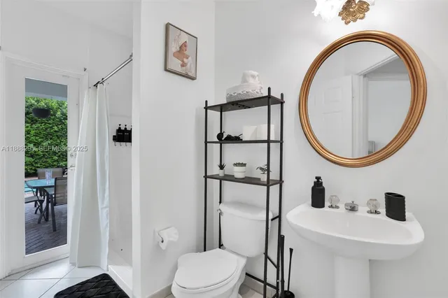 a bathroom with a sink a mirror a toilet and a shower