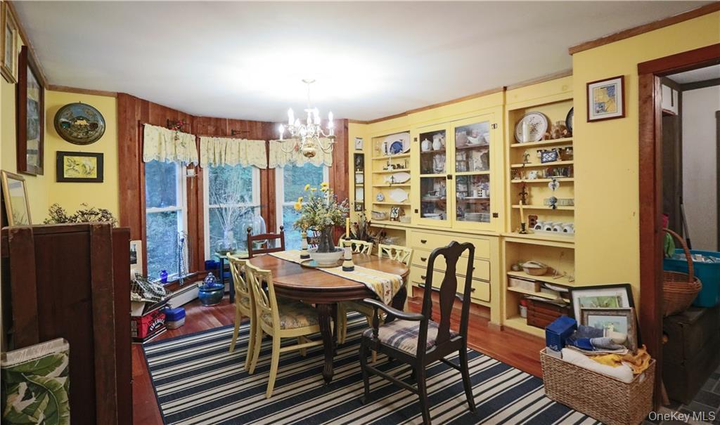 446 Shandelee Road Livingston Manor, NY 12758 - Photo 20 of 33 Dining space featuring a chandelier, wood finished floors, ornamental molding, and built in shelves
