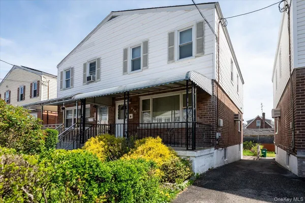 a view of a house with wooden fence next to a yard