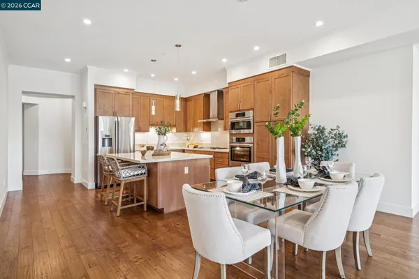 a kitchen with a dining table chairs and refrigerator