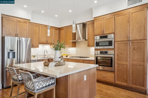 a kitchen with kitchen island granite countertop a sink appliances and cabinets