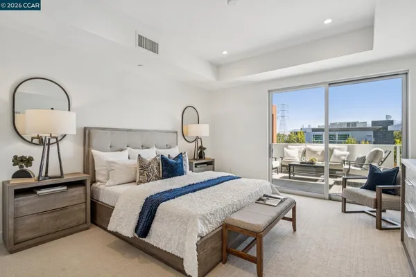 a bedroom with a bed large window with table and chairs