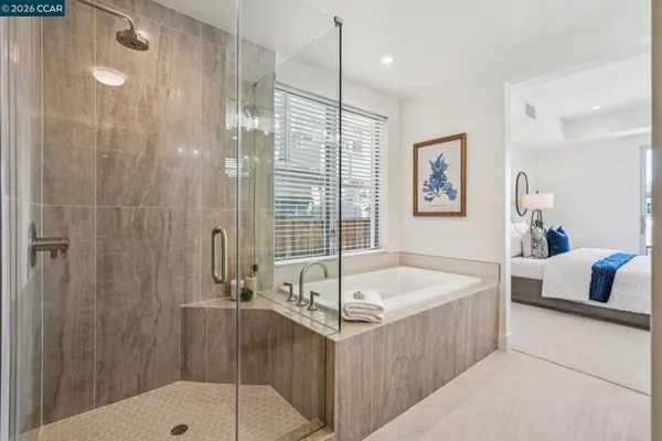 a bathroom with a tub a sink and glass door