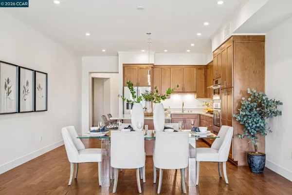 a dining room with furniture potted plants and wooden floor