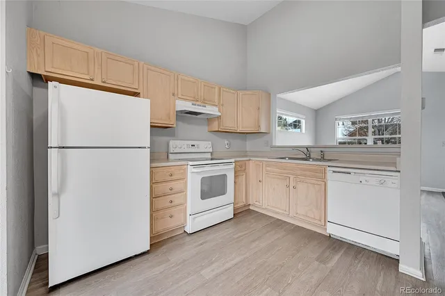 a kitchen with white cabinets and white appliances