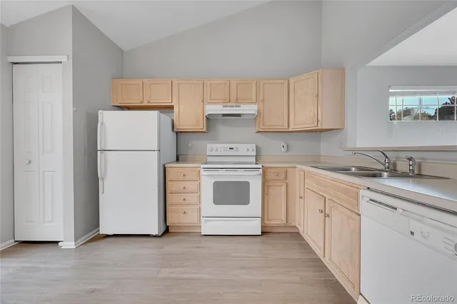 a white kitchen with cabinets and white appliances