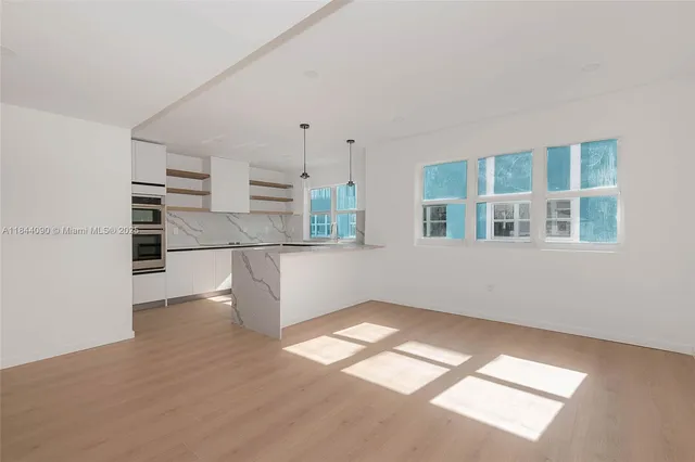 a view of empty room with wooden floor and windows