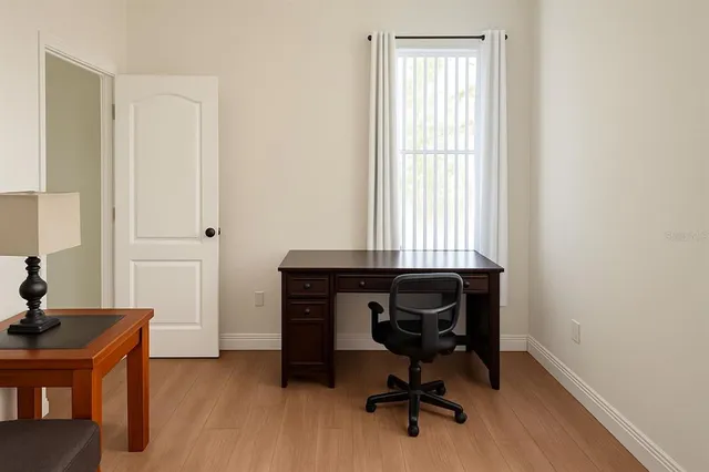 a view of a workspace with furniture and a window