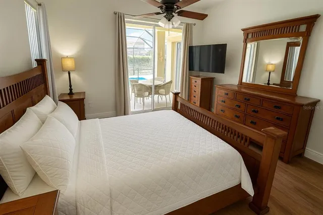 a bedroom with a bed a flat screen tv and a chandelier