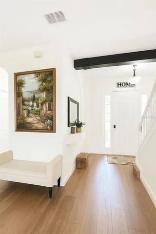 a view of a big room with wooden floor and windows