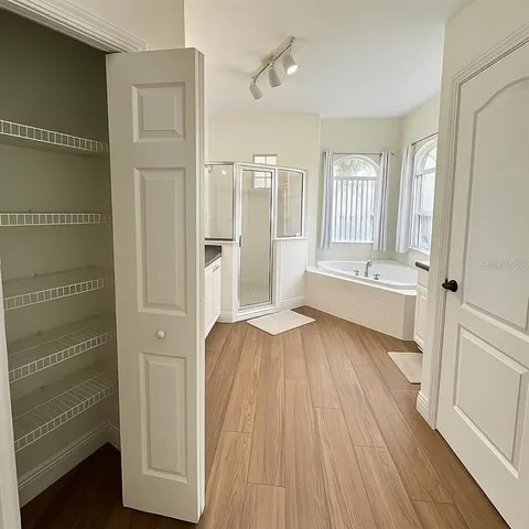 a view of a bedroom with wooden floor and windows