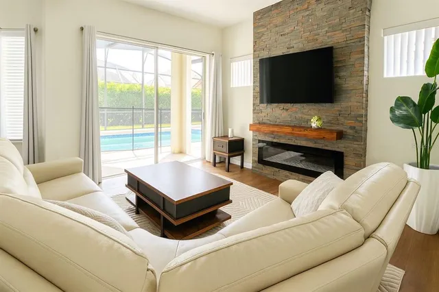a living room with furniture a flat screen tv and a fireplace