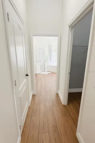 a view of a hallway with wooden floor and staircase