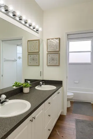 a bathroom with a granite countertop sink a toilet and a bathtub